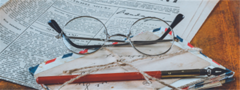 image of historical newspaper, a stack of old letters and reading glasses